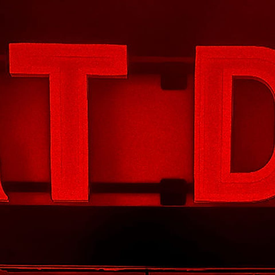 Red neon sign for "DIRT DOG" against a dark background.